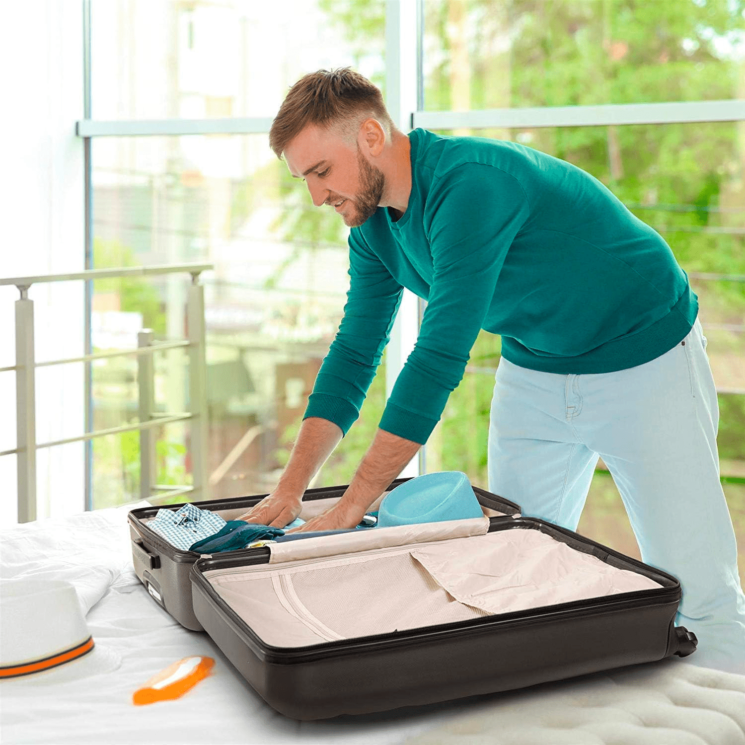 Man packing Aerolite suitcase on bed