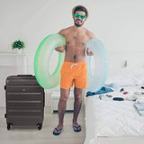 Man with beach gear and Aerolite suitcase in room