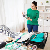 Person packing Aerolite luggage with clothes and travel items.