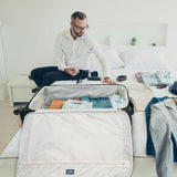 Man packing Aerolite suitcase on a bed